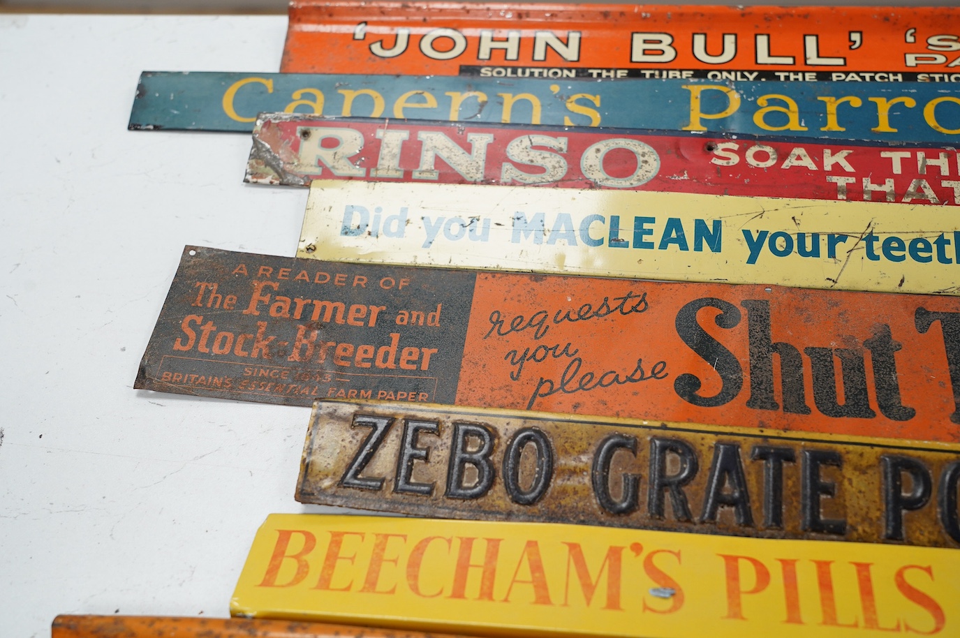 Eleven early / mid century tinplate advertising shelf strips, largest 60cm. Condition - poor to fair
